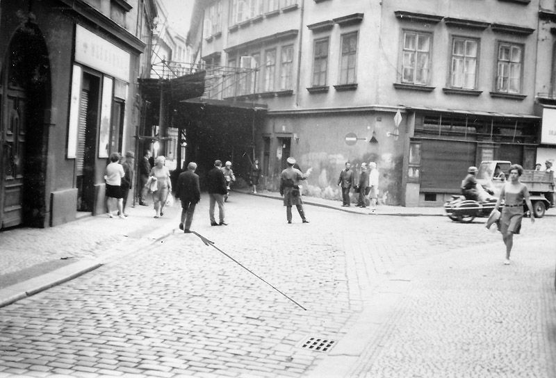 Pohled do Rybné ulice z místa, kde byl zasažen V. Kruba, šipkou označeno místo nálezu nábojnice ráže 7,62 mm (Zdroj ABS)